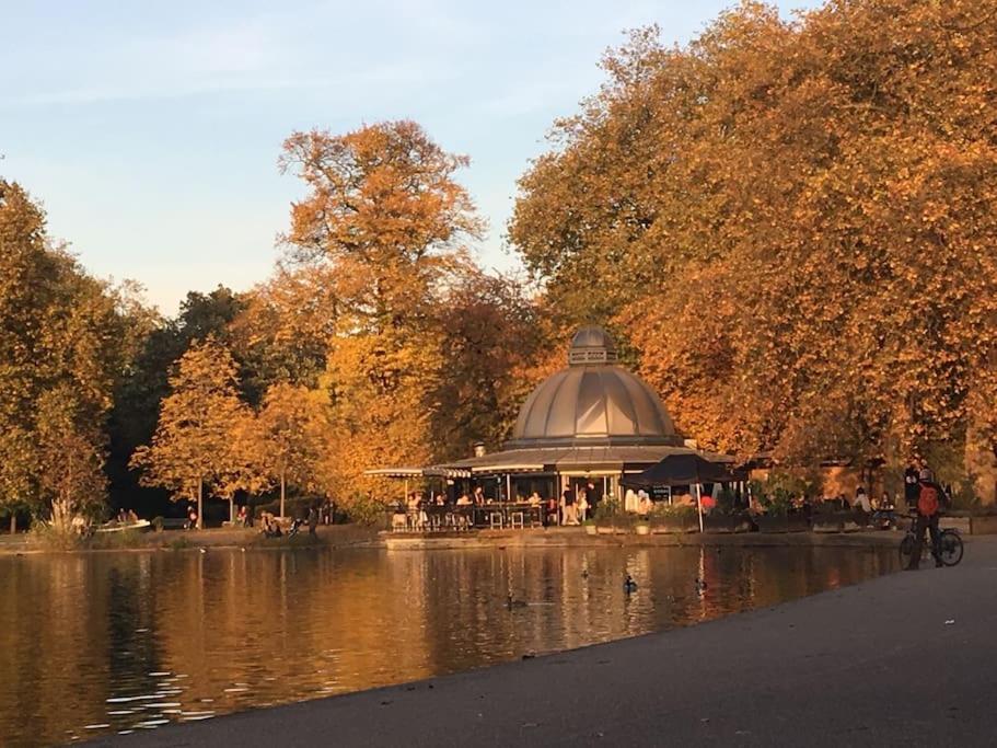 una persona che va in bicicletta davanti a un gazebo sopra un lago di Victoria Park 1 bedroom flat a Londra