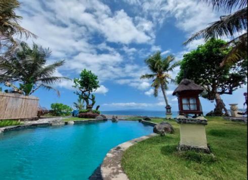 una piscina con luce accanto all'oceano di Abalone Sport Resort a Manggis