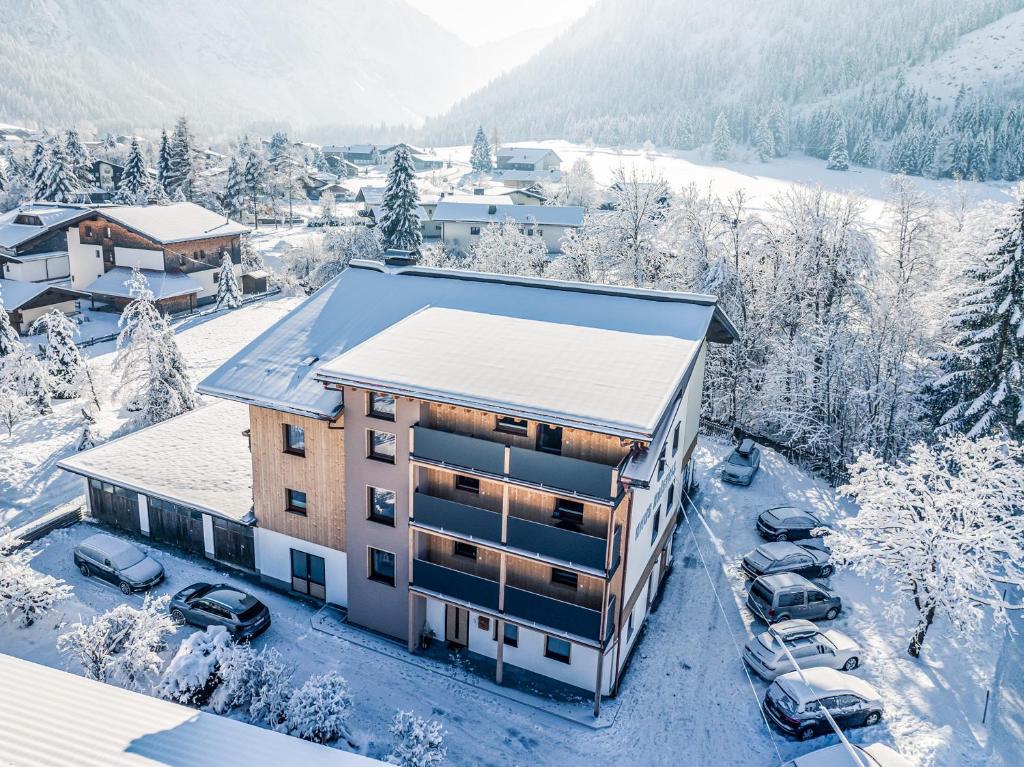 un condominio nella neve con auto parcheggiate di Haus Kristall a Tannheim