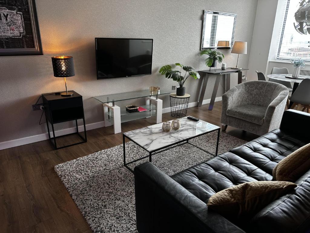 a living room with a couch and a tv at Stunning two bed city Center apartment in Liverpool