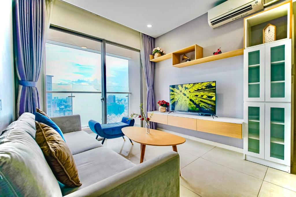 ein Wohnzimmer mit einem Sofa und einem TV in der Unterkunft Casa Par Grand Suites - Millennium Masteri, High-class and Central Location in Ho-Chi-Minh-Stadt