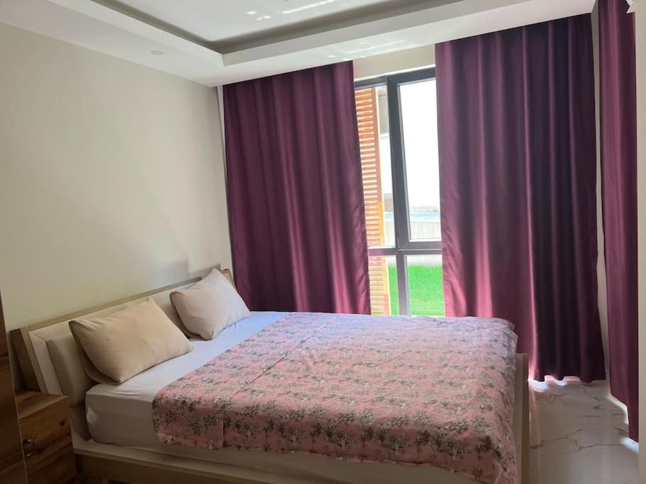 a bedroom with a bed with purple curtains and a window at Retro 3 in Alanya