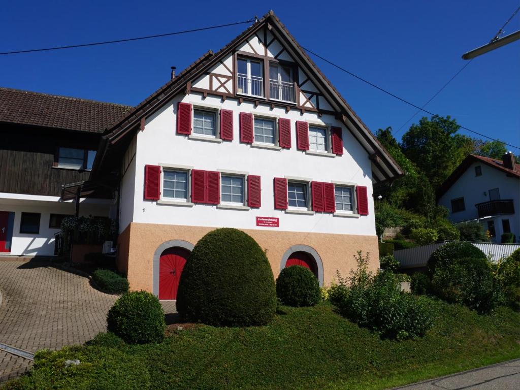 ein weißes und rotes Haus mit roten Rollläden in der Unterkunft Ferienwohnung Anna Durbach in Durbach