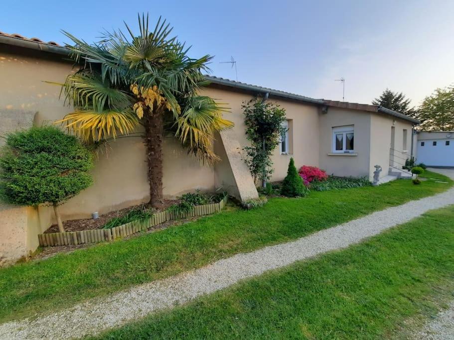 un palmier devant une maison dans l'établissement L'écrin de verdure à 25 minutes du Puy du Fou, à Cerizay