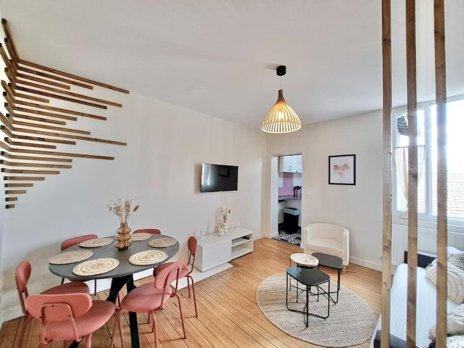 un salon avec une table et quelques chaises dans l'établissement Appartement Cosy, à Reims