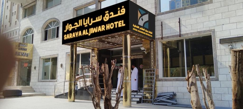 a man standing outside of a building with a sign at فندق سرايا الجوار - SARAYA ALJIWAR HOTEL in Makkah