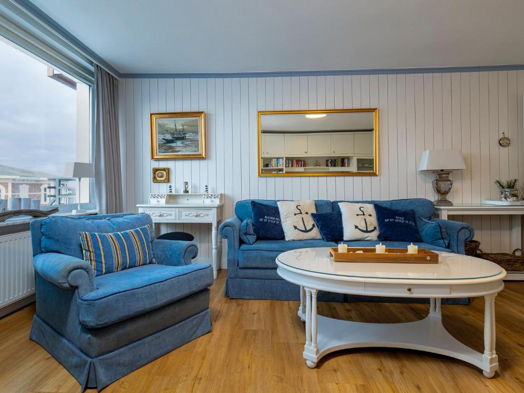 ein Wohnzimmer mit einem blauen Sofa und einem Tisch in der Unterkunft Appartement Strandnah in Westerland