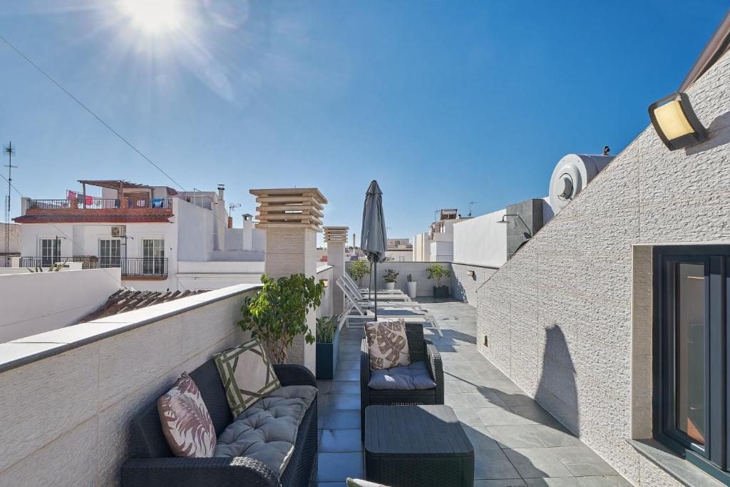 a balcony with couches and chairs on a building at Solaga - Nueva 22 in Nerja