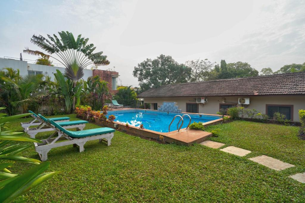 a backyard with a swimming pool and a house at Casa De Royale - Anjuna in Anjuna