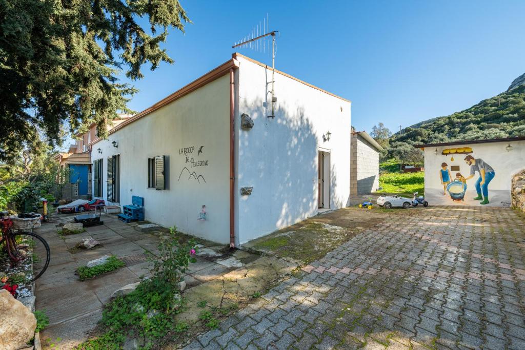 un edificio bianco con un murale sul lato di La Rocca del Pellegrino a Carbonia