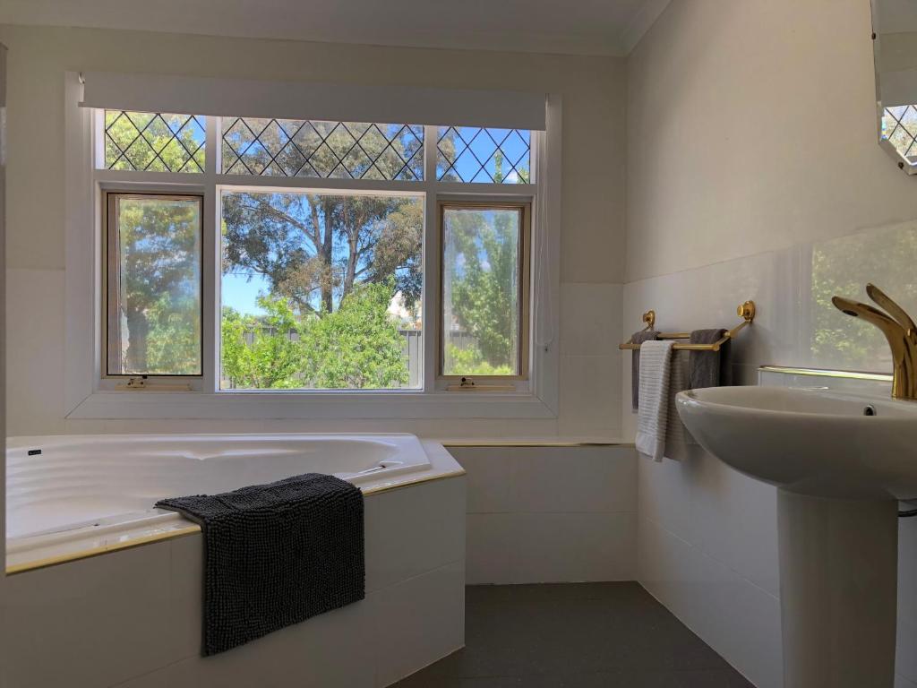 a bathroom with a tub and a sink and a window at Clare to Spalding character escape in Spalding