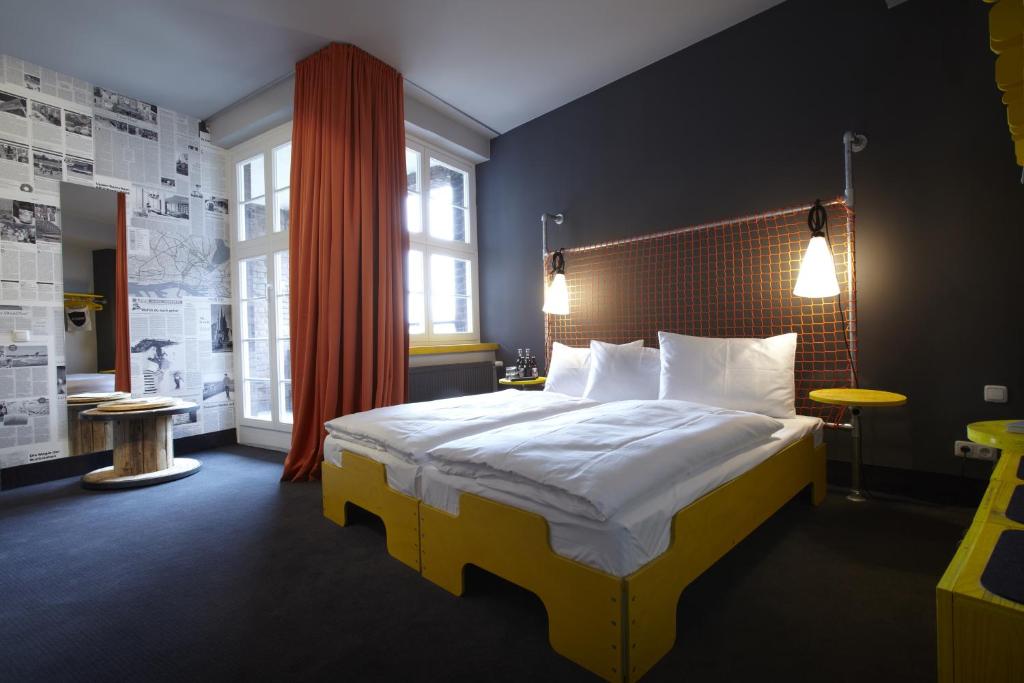 ein Schlafzimmer mit einem großen Bett mit weißer Bettwäsche und Kissen in der Unterkunft Superbude Hamburg St Pauli in Hamburg