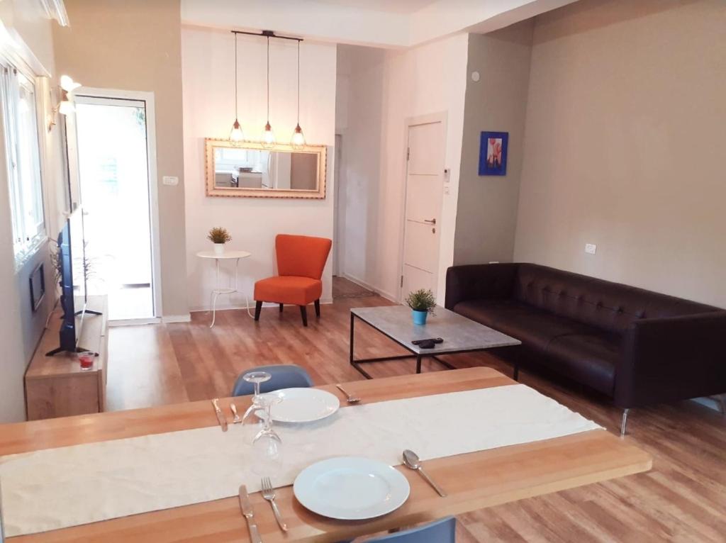 a living room with a couch and a table at magical apartment close to the Baha'i Gardens in Haifa