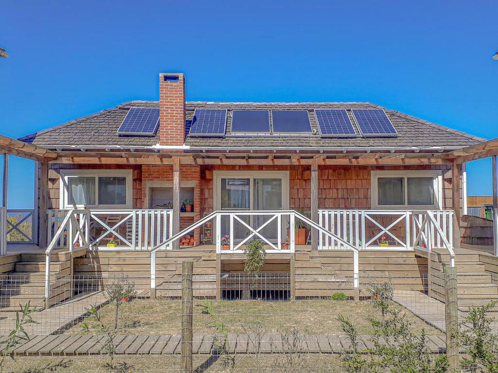 a house with solar panels on the roof at Charming Cottage in Punta Del Diablo