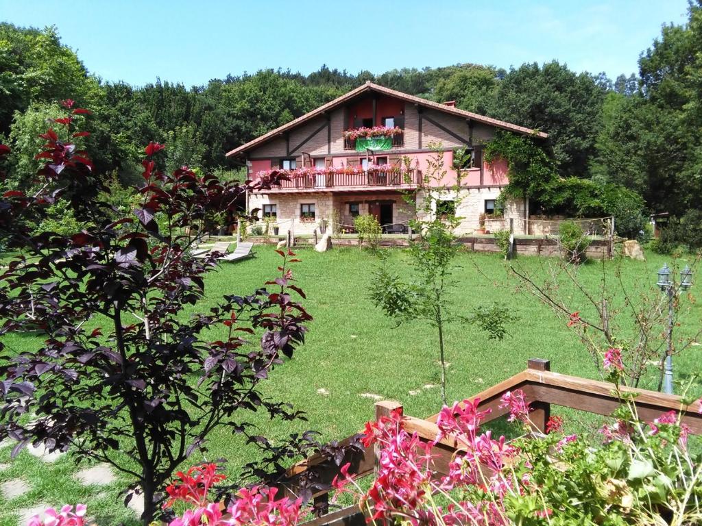 a house in the middle of a yard with flowers at Casa Rural Haritzpe in Hondarribia