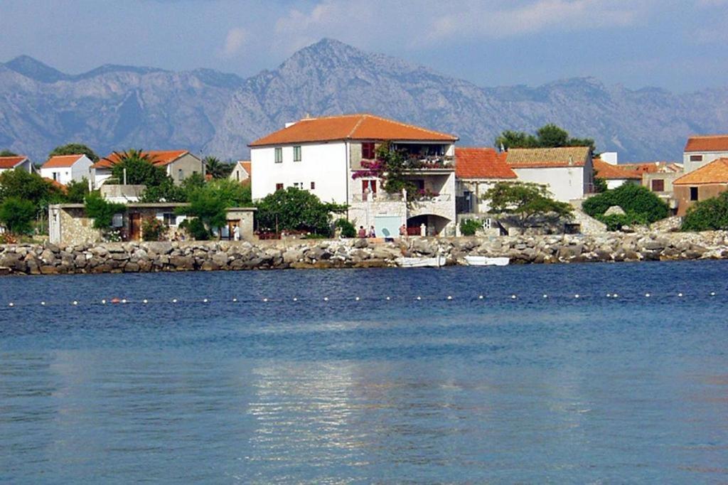 a group of houses on the shore of a body of water at Apartments Bartul in Sućuraj
