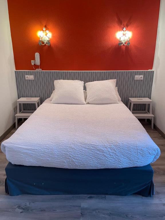 - une chambre avec un lit et deux lumières sur le mur dans l&#39;établissement Logis Hôtel Le Clement V, à Roquemaure