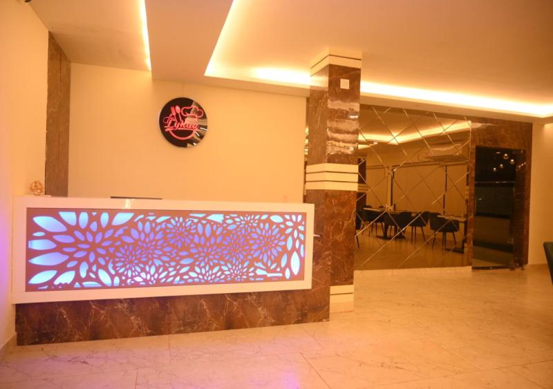 a lobby with a sign on the wall and a clock at Atithi Regency in Dhuburi