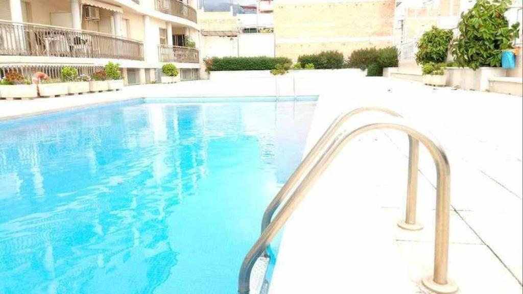A H Rentals Carles III Apartamento 150mtrs playa في سانت كارليس دي لا رابيتا: مسبح في مبنى به ماء ازرق