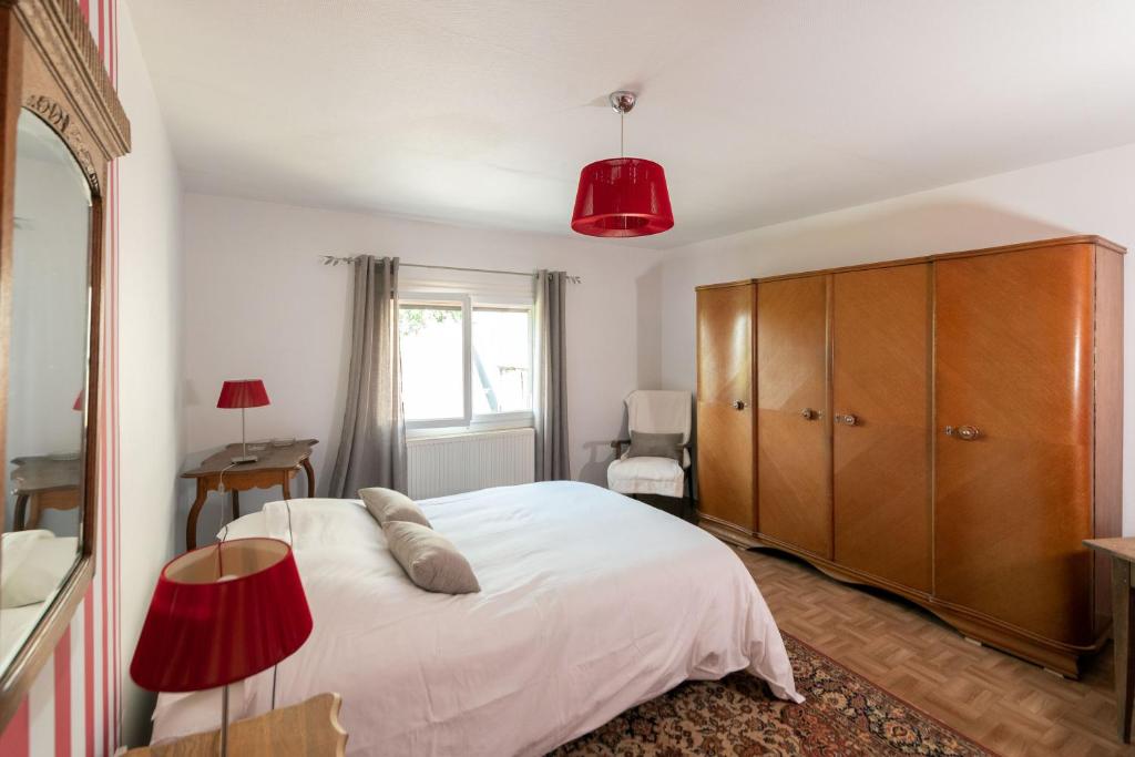 a bedroom with a white bed and a wooden cabinet at le Guydine 