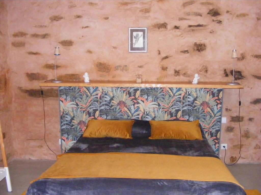 een bed in een kamer met een muur bij LES ANGES in Covelo
