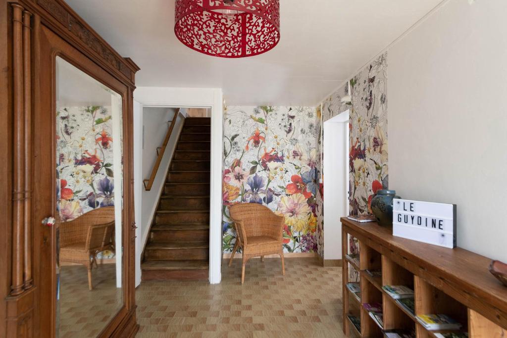 a hallway with a staircase with floral wallpaper at le Guydine 