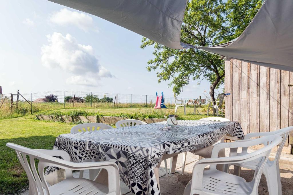 a table with white chairs and a table and a table and chairs at le Guydine 