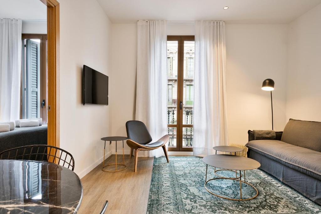 a living room with a couch and a table at Vale Suites in Barcelona