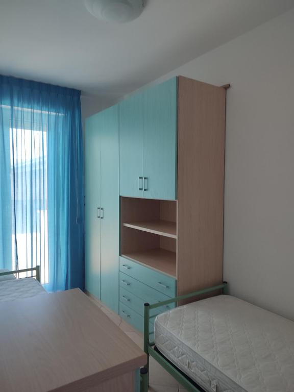 a bedroom with a bed and a blue cabinet at Appartamenti Piccola Stella Maris in Senigallia