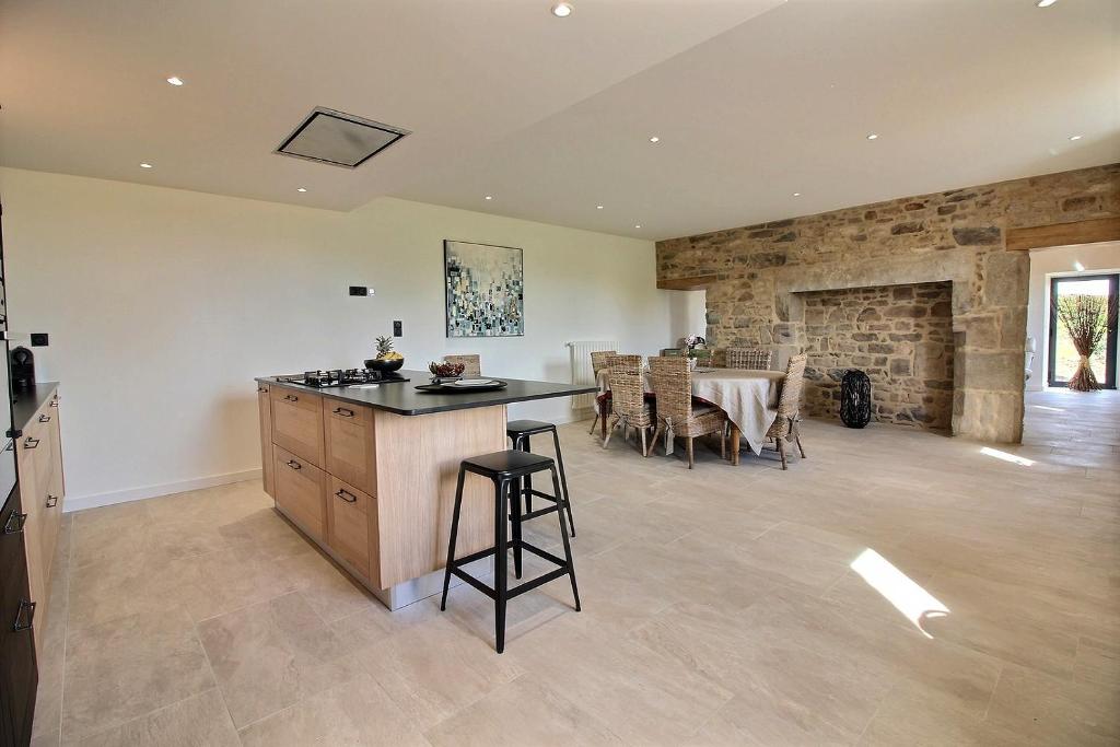 a kitchen and dining room with a stone wall at A l'abri des pins in Pleubian