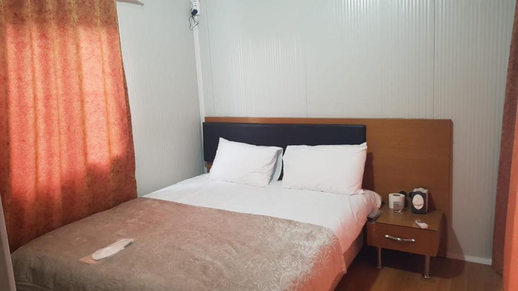 Schlafzimmer mit einem Bett mit einem Kopfteil aus Holz in der Unterkunft GÜN IŞIĞI KONAKLAMA in Hatay