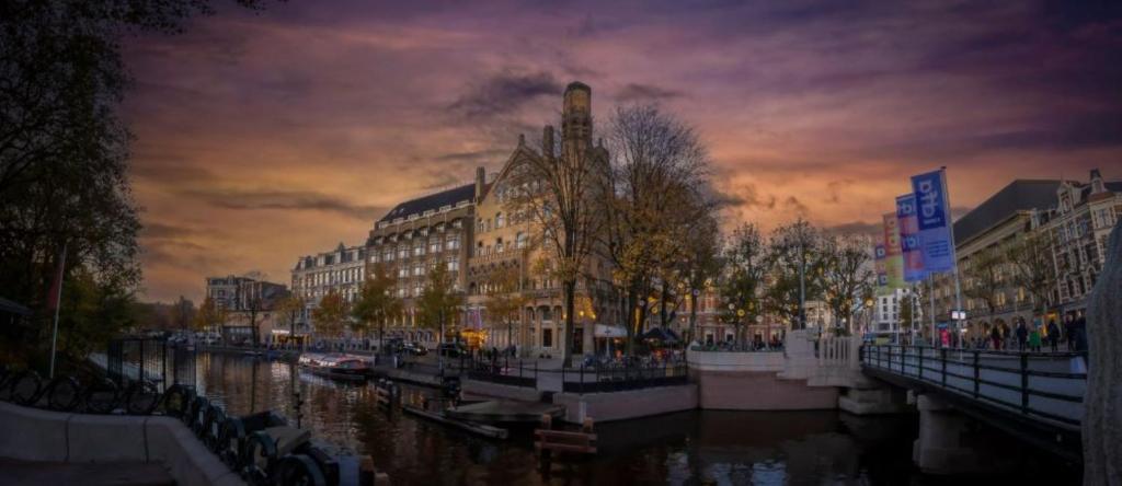 Blick auf eine Stadt mit Gebäuden und einen Fluss in der Unterkunft Clayton Hotel Amsterdam American in Amsterdam