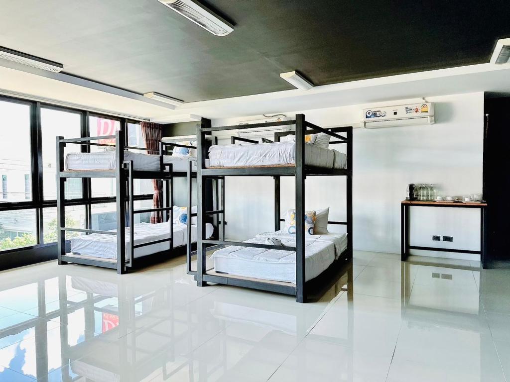 a room with three bunk beds in it at Dm Inn in Khon Kaen