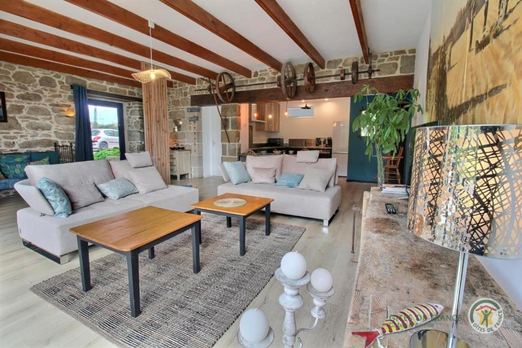 a living room with a couch and a table at La grange in Penvénan
