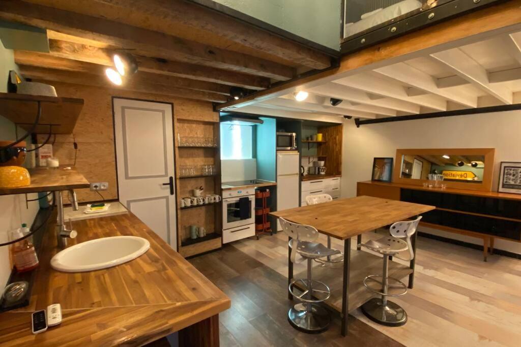 a kitchen with a wooden table and a counter top at Vaste T2 Duplex Lille Beaux Arts - Renaud in Lille