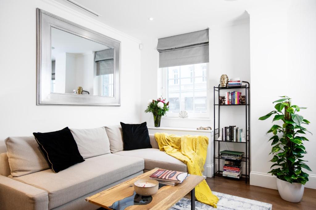 uma sala de estar com um sofá e uma mesa em Elegant central London flat - ideal for weekend city break em Londres