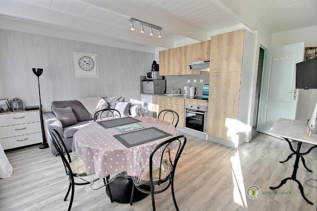 eine Küche und ein Wohnzimmer mit einem Tisch und einem Sofa in der Unterkunft Le ploubaz in Ploubazlanec