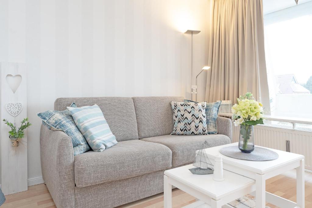 ein Wohnzimmer mit einem Sofa und einem Tisch in der Unterkunft Appartementanlage Kammerweg 5-5b Kleinaberfein in Scharbeutz