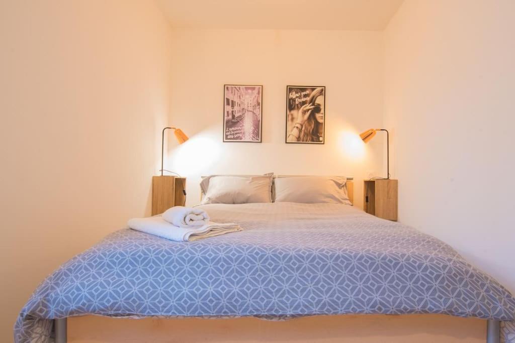 ein Schlafzimmer mit einem blauen Bett mit zwei Lampen in der Unterkunft Le safari 