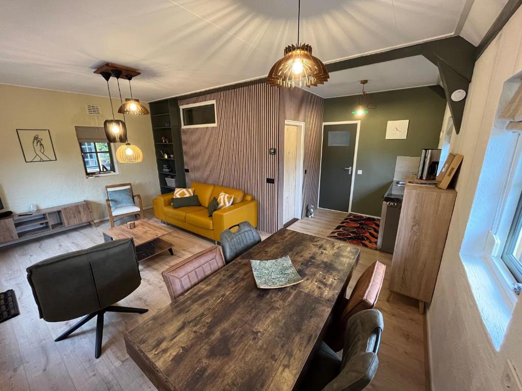 uma sala de estar com uma mesa de madeira e um sofá amarelo em Bed & Breakfast Appenseweg em Voorst