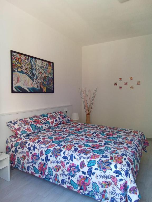 een slaapkamer met een bed met een kleurrijk dekbed bij Appartamenti Milietta 1 in Monzambano