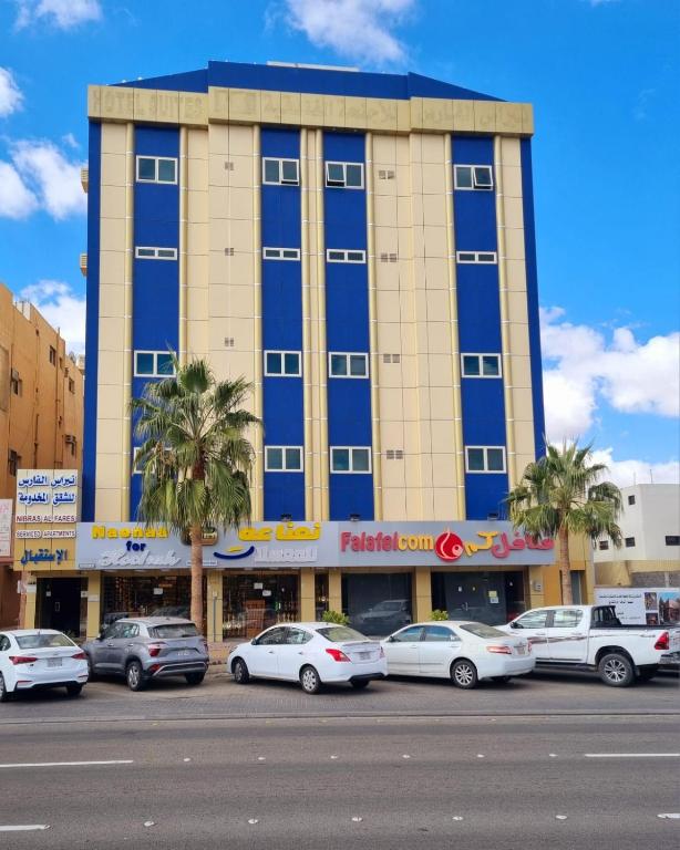a large building with cars parked in front of it at شقق نبراس الفارس للشقق المخدومة - اقتصادي in Tabuk