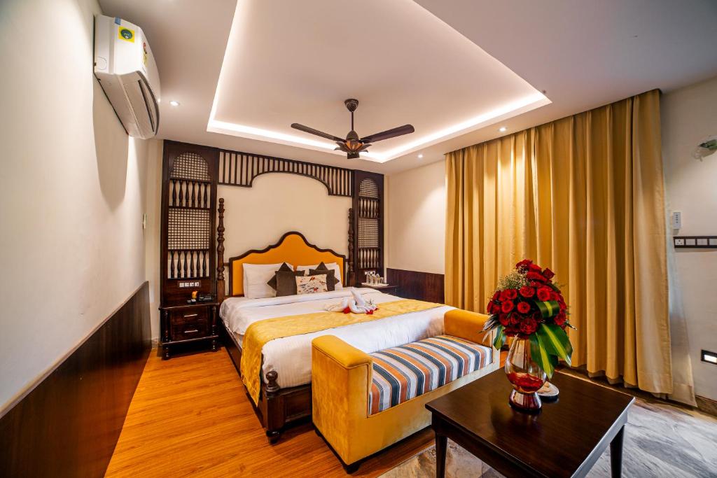 a hotel room with a bed and a couch at Manu Maharani Resort in Rāmnagar