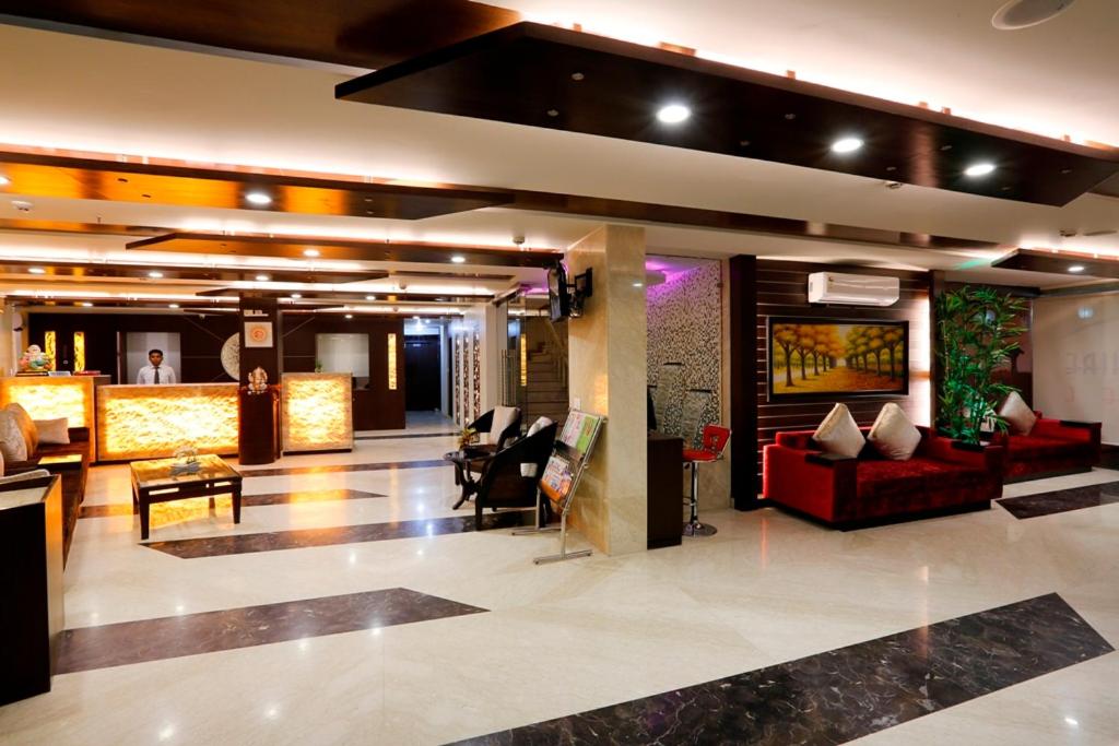 a lobby of a hotel with red furniture and a bar at LA SAPPHIRE HOTEL & RESTUARANT in New Delhi