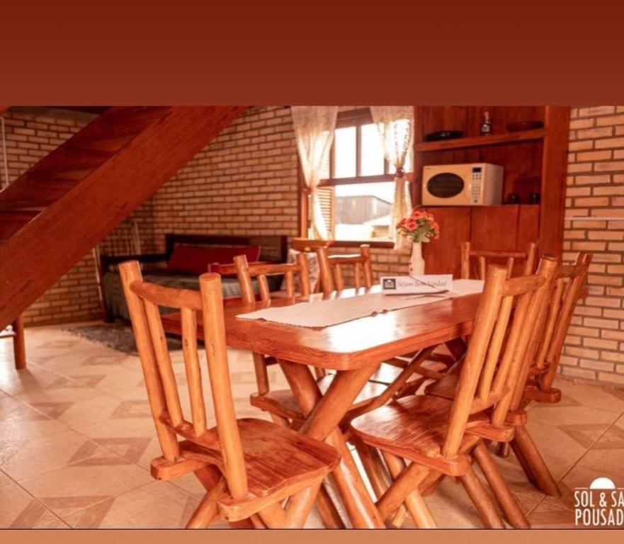 Sol sal cabana p 10 في إيمبيتوبا: غرفة طعام مع طاولة وكراسي خشبية