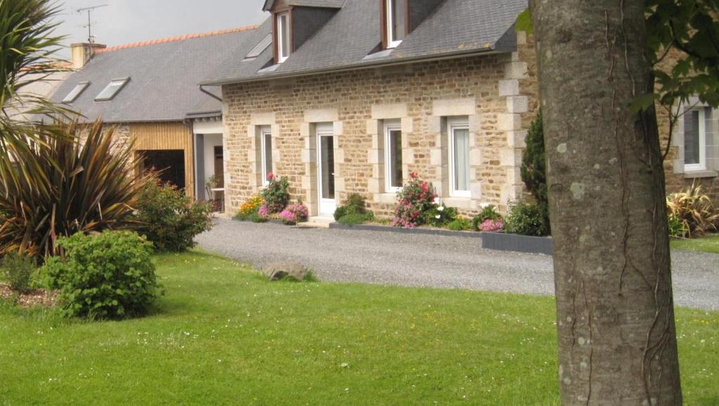 une maison avec une allée en gravier en face de celle-ci dans l'établissement Gite de la glanerie, à Coëtmieux