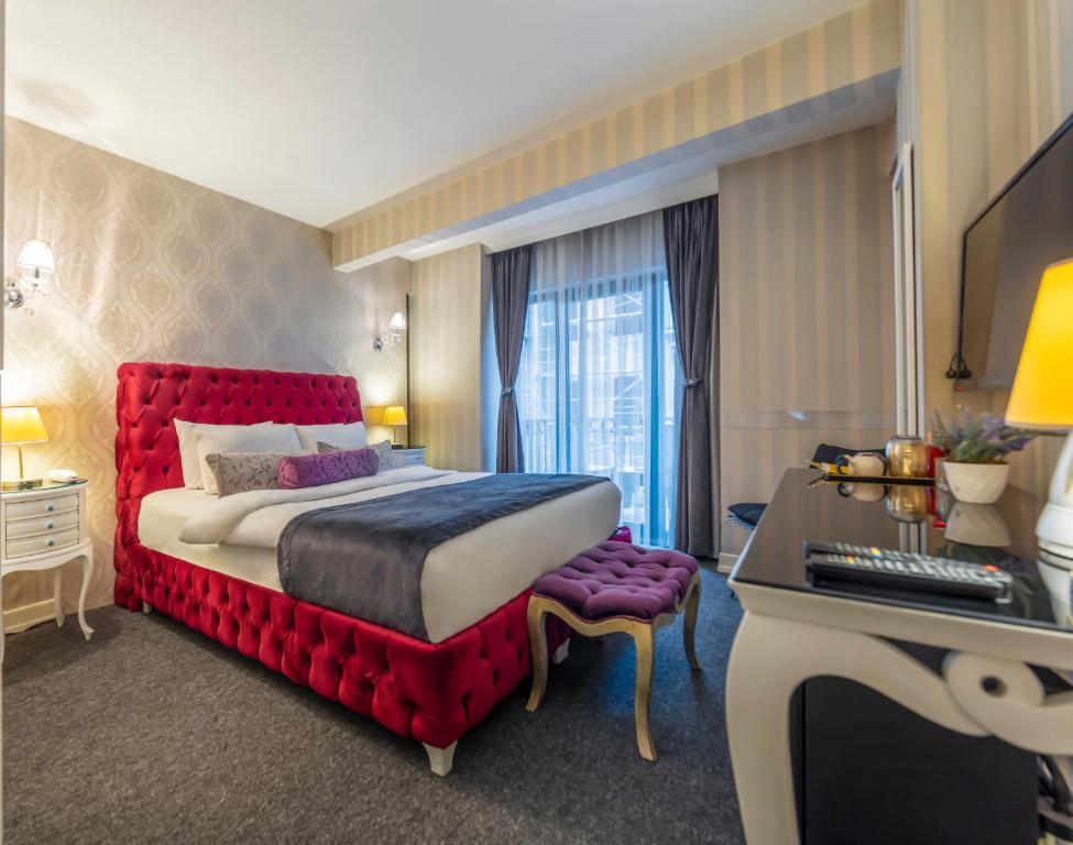 a hotel room with a red bed and a desk at In Pera Boutique Hotel in Istanbul