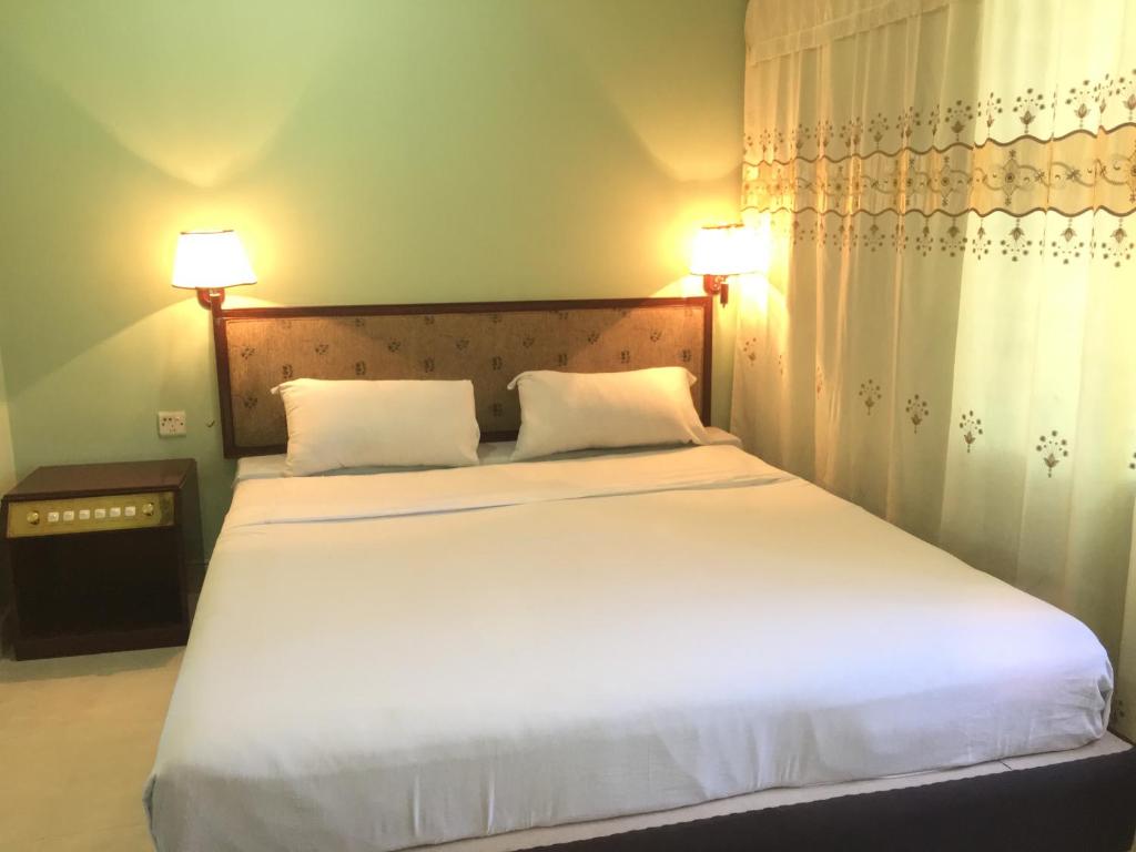 吉大港Hotel City Inn的卧室里有一张白色的大床，上面有两个枕头