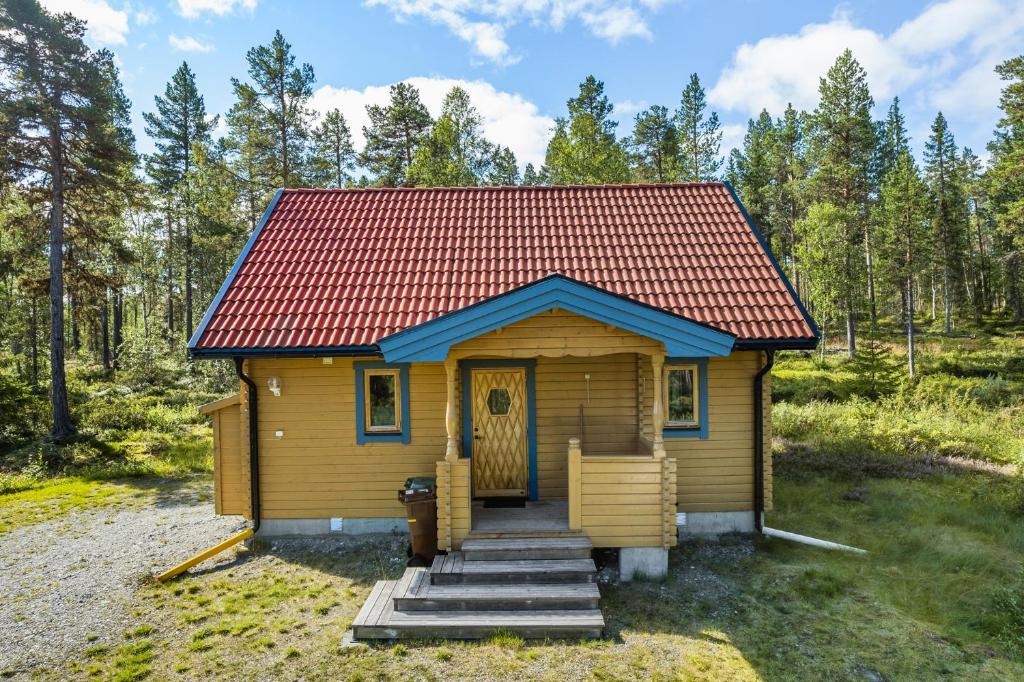 Cabaña pequeña con techo rojo en el bosque en Stuga i Funäsdalen, en Funäsdalen