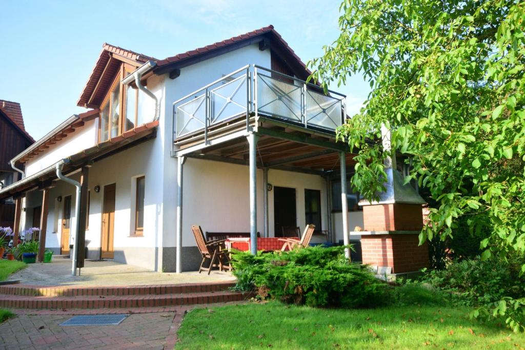 een huis met een balkon en een patio bij Ferienwohnung Gartenblick am Schweriner See in Schwerin